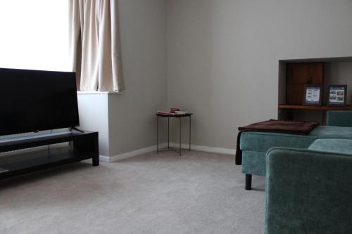 a living room with a couch and a flat screen tv at Luxe Entire 3 Bed Home - LHR 15 mins - London City 35 mins in Denham