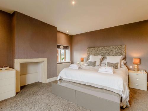 a bedroom with a large white bed and a fireplace at 3 Bed in Halifax 90209 in Sowerby Bridge