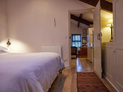 a bedroom with a white bed and a living room at 1 Bed in Ullswater 94066 in Watermillock