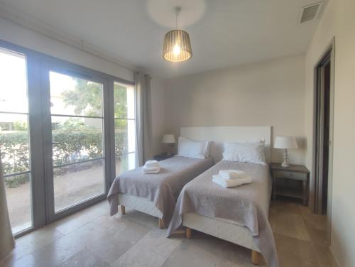 a bedroom with a bed and a large window at Villa Élegancia - Piscine privé - Wifi - 18 in Laredorte