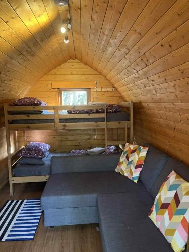 a room with two bunk beds and a couch in a cabin at Pine Marten Bar Glenmore Pods in Aviemore