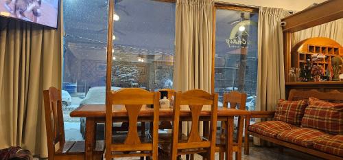 Hosteria Chalp في أوشوايا: طاولة طعام وكراسي أمام النافذة