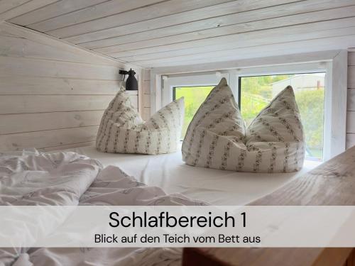 a bedroom with a bed with pillows on it at TinyHousebeiDresden klein aber fein, beste Alleinlage direkt am Naturteich, große Terrasse - Nähe Sächsische Schweiz und Dresden in Großharthau