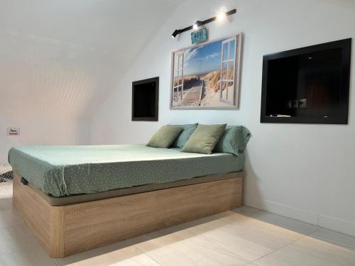 a bed in a room with a tv on the wall at Carihuela Home in Torremolinos