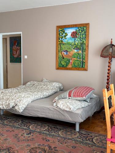 two beds in a room with a painting on the wall at Villa appartment in Vinohrady