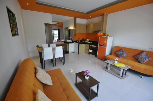 a living room with a couch and a table at Duangjai Residence - SHA Extra Plus in Rawai Beach