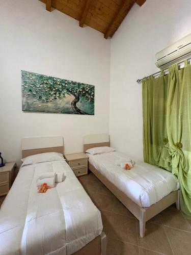 two beds in a room with a painting on the wall at Villa Sofia Casa Vacanze in Marconia