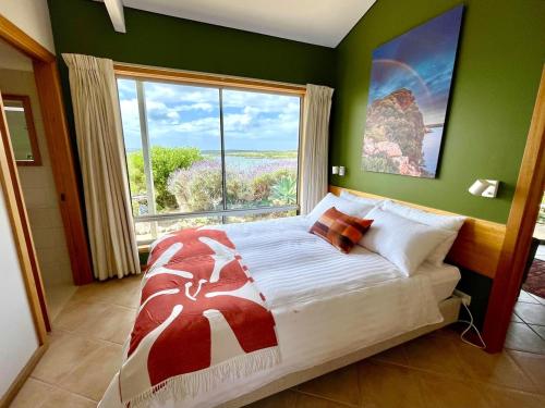 a bedroom with a large bed with a large window at Moonrise Cove in Pelican Lagoon