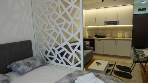 uma sala de estar com uma divisória com uma parede branca em Apartman studio KOPS em Vranješ