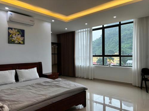 a bedroom with a bed and a large window at Ju Mông Hostel in Ha Giang