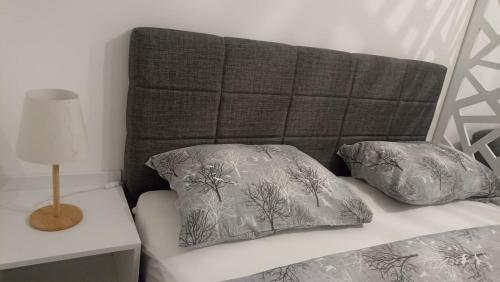uma cama com cabeceira e duas almofadas em Apartman studio KOPS em Vranješ