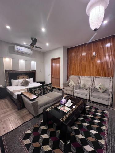 a room with a bed and a couch and a table at Park View Hotel Gulberg in Lahore