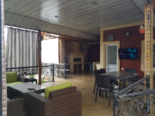 a patio with tables and chairs on a balcony at Villa in and Home Baku in Baku