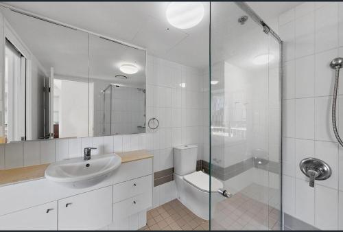 a bathroom with a toilet and a sink and a shower at Centre CBD - Pool Spa Gym - Water View - Sleep 4 in Brisbane