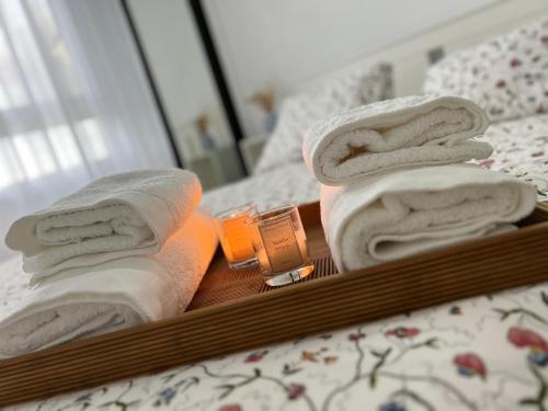 a tray with towels and a candle on a bed at Casa Rural Las Candelas in San Vicente de Alcántara