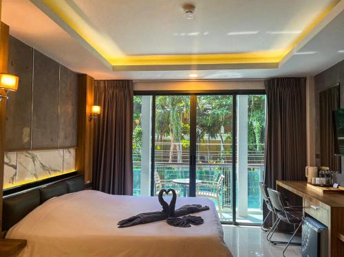 a hotel room with a bed with a towel on it at The Mantra Hotel Kata Noi in Kata Beach