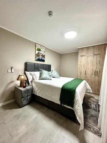 une chambre avec un grand lit dans une pièce dans l'établissement Cozy Loft, à Gaborone