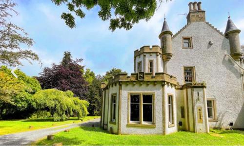 an old house with a tower on top of it at Harvieston Estate Rooms in Gorebridge