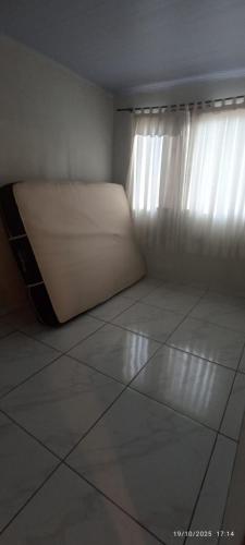 una piccola stanza con un letto e una finestra di Casa da edi a Piçarras