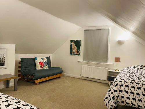 a bedroom with a bed and a chair and a window at Stylish & Spacious 2 Storey, 3 Bed Apartment in Kent