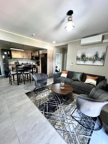 un salon avec un canapé et une table dans l'établissement Cozy Loft, à Gaborone