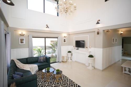 a living room with a couch and a tv at EKO STAY Gold - Gatsby Villa in Lonavala