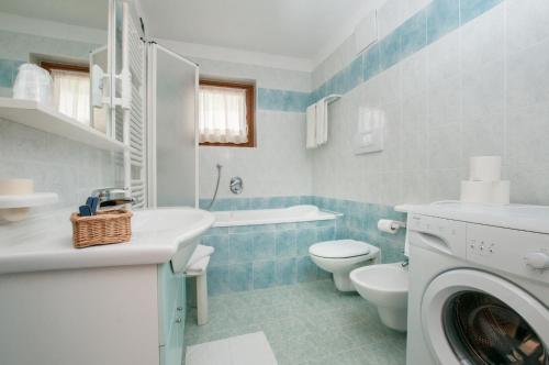 ein blau-weißes Bad mit einer Waschmaschine in der Unterkunft Centro Appartamenti Vacanze in Mezzana