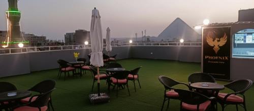 d'un toit-terrasse avec des tables et des chaises. dans l'établissement Phoenix Pyramids View Inn, au Caire