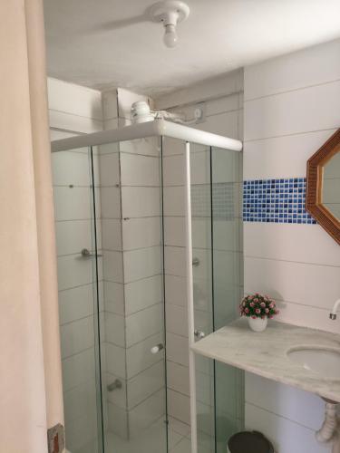 a bathroom with a glass shower and a sink at Reserva dos Corais in Cabo de Santo Agostinho