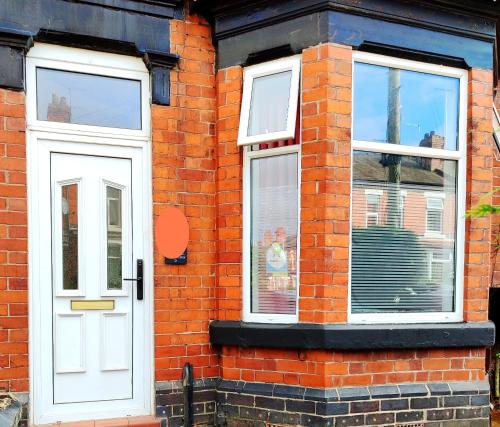 a brick house with a white door and windows at MagnoliaSuite in Crewe in Crewe