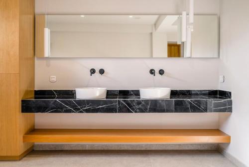 a bathroom with two sinks and a mirror at Allure Retreat Villa in Lefkada Town