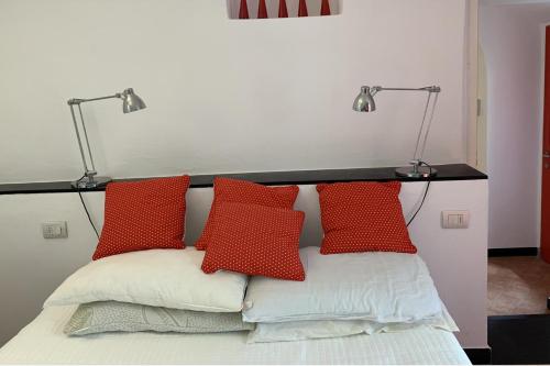 - un lit avec 3 oreillers rouges et 2 lampes dans l'établissement 1 Bed Cottage Sleeps 4 Private Garden - Pool, à Colletta