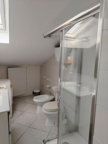 a bathroom with a toilet and a glass shower at Carmenhouse in Montesilvano