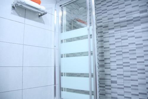y baño con ducha y puerta de cristal. en Apartamento Orange Triana centro, en Sevilla