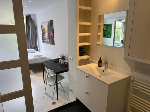 a bathroom with a sink and a table and a mirror at Amsliving in Amsterdam