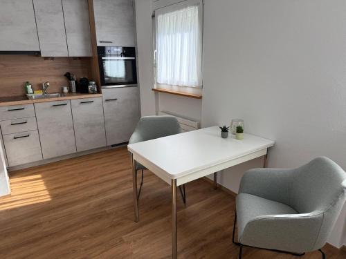 a kitchen with a white table and two chairs at Charmantes Studio in Chur - alles in Reichweite in Chur