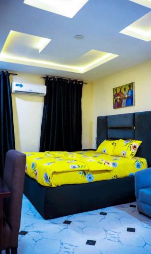 a bedroom with a bed with a yellow blanket at A1 Pinnacle Serviced Apartment in Oshogbo