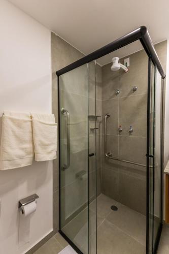 a shower with a glass door in a bathroom at Studio Conforto a 15Min da USP e perto do mêtro butantã in São Paulo