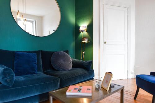 un salon avec un canapé bleu et un miroir dans l'établissement T3 Havre de paix 6p - 115m Cœur Saint Sernin Toulouse - PKG 3 min, à Toulouse