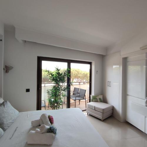 a white bedroom with a large white bed and a balcony at VILLAS COSETTE Apartamento NEPTUNO 224 ALQUILER TEMPORAL 