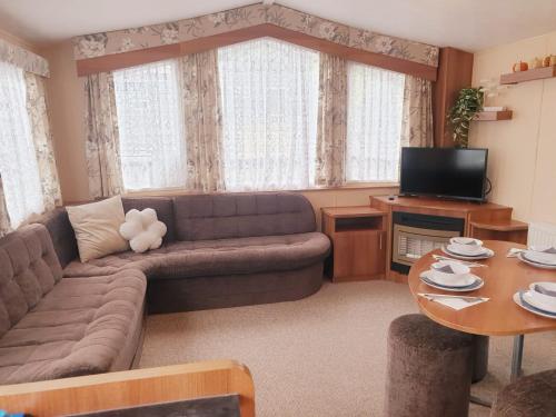a living room with a couch and a table at Lady's Mile in Dawlish Warren