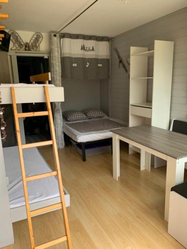 een kamer met een stapelbed, een tafel en een bureau bij Avec balcon, au pied des pistes et randos in Villard-de-Lans