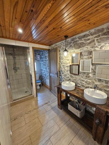 a bathroom with two sinks and a walk in shower at Gîte de caractère tout confort "Au Clos des Ammonites chez Ange&Sébastien " in Labeaume