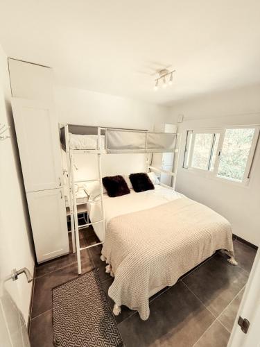 a bedroom with a white bed with two pillows at APARTAMENTO PRECIOSO SOL Y SIERRA in Sierra Nevada