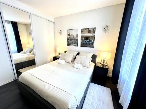 a bedroom with a bed with white sheets and pillows at Superbe 4pers - Saint-mandé, 200m Paris in Saint-Mandé