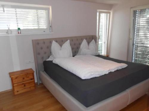 a bed with white sheets and pillows in a bedroom at Dornbirn Zentrum Bahnhof in Dornbirn