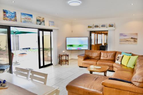 スワコプムントにあるBeach View Retreatの革張りの家具と薄型テレビを備えたリビングルーム