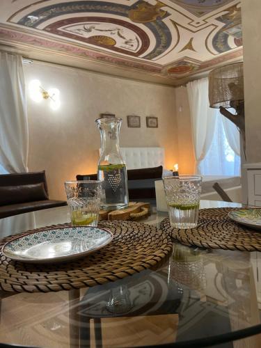 a table with glasses and a vase on top of it at FresCo b&b in Sarnico