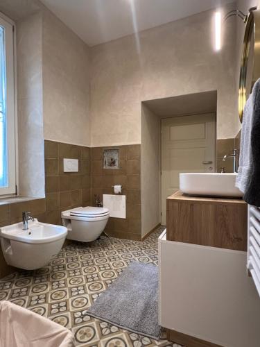 a bathroom with two sinks and a toilet and a tub at FresCo b&b in Sarnico
