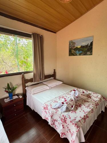 a bedroom with a bed and a window at Pousada Mangaba da Serra in Serra do Cipo